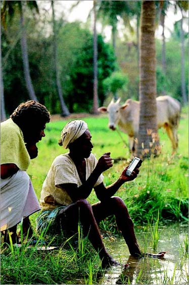 Farmer using a Simputer (Simple Inexpensive Mobile Computer) to check crop prices, Bangalore, 2002, Dilip Mehta