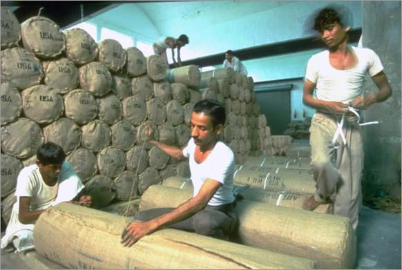 Arvind Mills workers packing rolls of denim fabric for shipment to U.S., Ahmedabad, 1994, Dilip Mehta